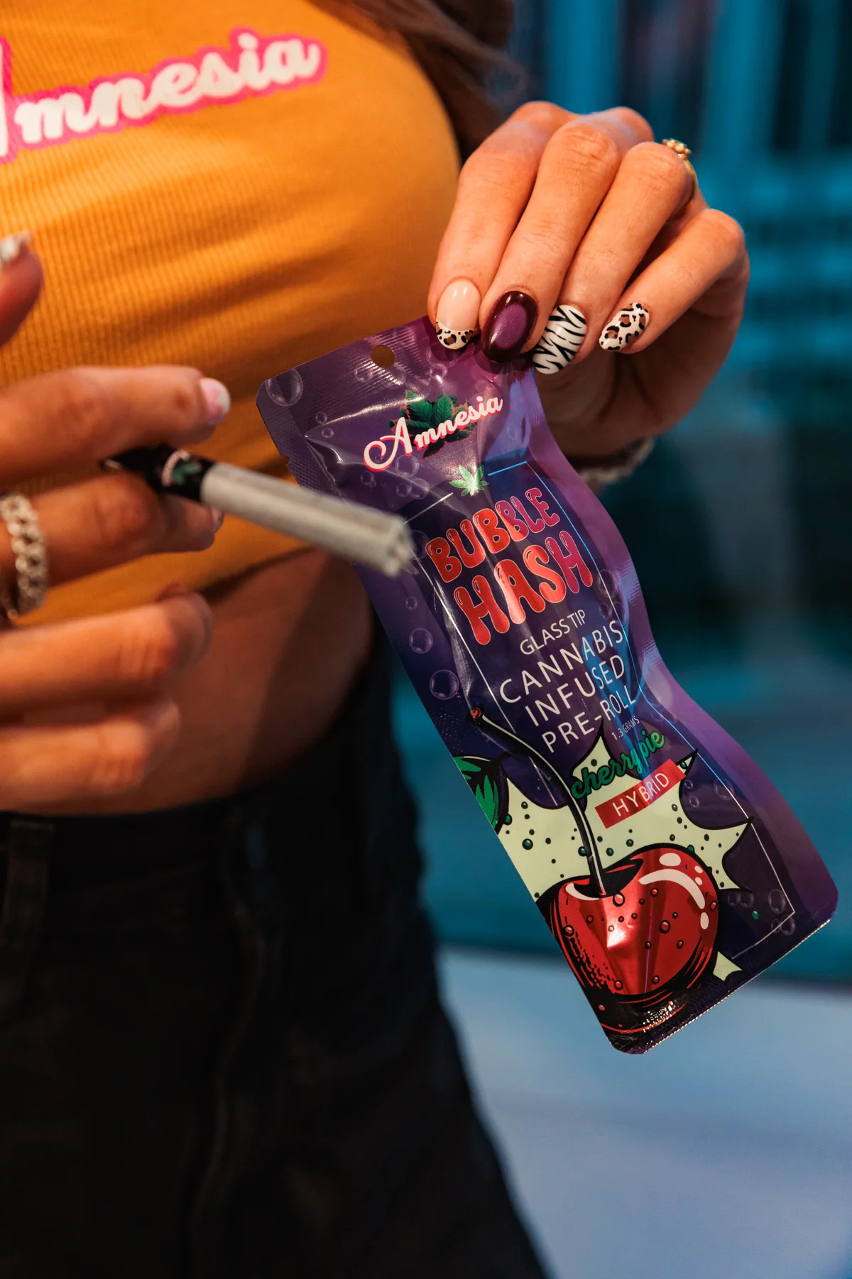 Model holding Cherry Pie Hybrid Bubble Hash glass-tip infused pre-roll packaging